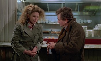 Movie still from “Wings of Desire” (1987), directed by Wim Wenders – A man and a woman are talking in a kitchen; Medium shot, Over the shoulder angle