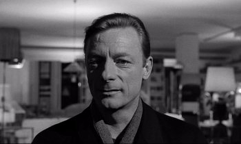Movie still from “Wings of Desire” (1987), directed by Wim Wenders – Black and white photograph of a man in a suit; Close Up shot, Over the shoulder angle