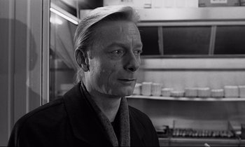 Movie still from “Wings of Desire” (1987), directed by Wim Wenders – Black and white photograph of a man in a kitchen; Close Up shot, Over the shoulder angle