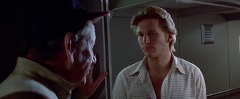 Movie still from “Winter Kills” (1979), directed by William Richert – A man in plaid shirt looking in the mirror; Close Up shot, Over the shoulder angle