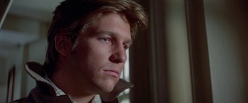 Movie still from “Winter Kills” (1979), directed by William Richert – A person looking at the camera; Close Up shot, Low angle