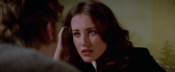 Movie still from “Winter Kills” (1979), directed by William Richert – A person with long dark hair; Close Up shot, Over the shoulder angle