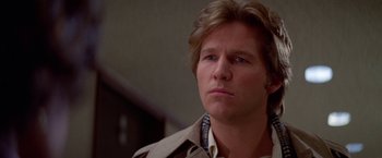 Movie still from “Winter Kills” (1979), directed by William Richert – A person wearing a trench coat; Close Up shot, Low angle