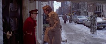 Movie still from “Winter Kills” (1979), directed by William Richert – A man in a trench coat talking to a man in a uniform; Medium shot, Over the shoulder angle