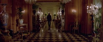 Movie still from “Winter Kills” (1979), directed by William Richert – A man walking down a hall way in a building; Wide shot, Over the shoulder angle