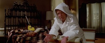 Movie still from “Winter Kills” (1979), directed by William Richert – An older man in a robe and a white robe; Medium shot, Low angle