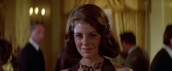 Movie still from “Winter Kills” (1979), directed by William Richert – A person wearing a necklace; Close Up shot, Low angle