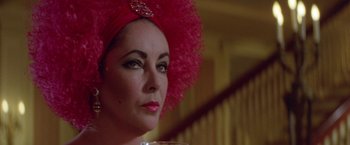 Movie still from “Winter Kills” (1979), directed by William Richert – A person wearing a pink hat; Close Up shot, Over the shoulder angle