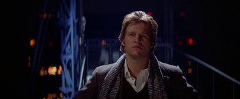 Movie still from “Winter Kills” (1979), directed by William Richert – A person wearing a jacket and a scarf; Close Up shot, Low angle