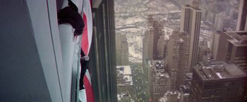 Movie still from “Winter Kills” (1979), directed by William Richert – An american flag hanging from the side of a skyscraper; Wide shot, Low angle