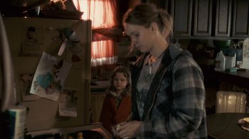 Movie still from “Winter's Bone” (2010), directed by Debra Granik – A woman and a child are looking at something on a tablet; Medium shot, Over the shoulder angle