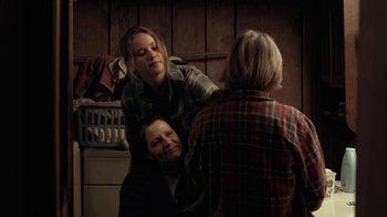 Movie still from “Winter's Bone” (2010), directed by Debra Granik – A woman is combing another woman's hair in a bathroom; Medium shot, Over the shoulder angle