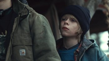 Movie still from “Winter's Bone” (2010), directed by Debra Granik – A young boy wearing a hat and a jacket; Close Up shot, Over the shoulder angle