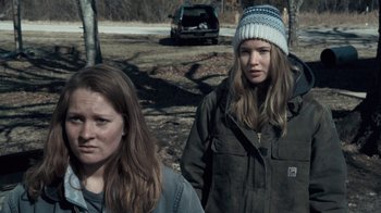 Movie still from “Winter's Bone” (2010), directed by Debra Granik – Two young women standing next to each other in a wooded area; Close Up shot, Over the shoulder angle