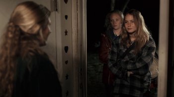 Movie still from “Winter's Bone” (2010), directed by Debra Granik – Two young women standing in front of a door; Medium shot, Over the shoulder angle