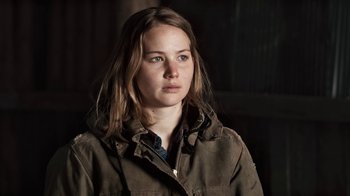 Movie still from “Winter's Bone” (2010), directed by Debra Granik – A woman with long brown hair wearing a brown jacket; Close Up shot, High angle