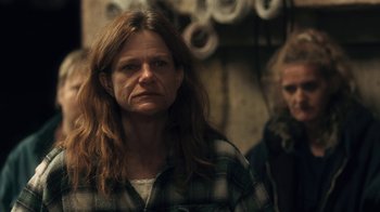 Movie still from “Winter's Bone” (2010), directed by Debra Granik – A woman in a plaid shirt is looking at the camera; Close Up shot, Over the shoulder angle