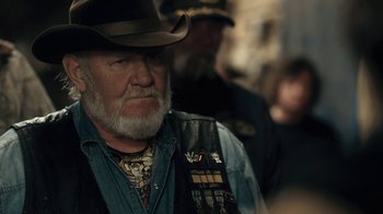 Movie still from “Winter's Bone” (2010), directed by Debra Granik – An older man wearing a cowboy hat and a leather vest; Close Up shot, Over the shoulder angle