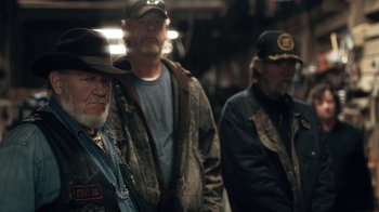 Movie still from “Winter's Bone” (2010), directed by Debra Granik – A group of men standing next to each other; Medium shot, Over the shoulder angle