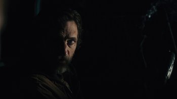 Movie still from “Winter's Bone” (2010), directed by Debra Granik – A man with a beard is looking at the camera; Close Up shot, Over the shoulder angle