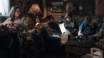 Movie still from “Winter's Bone” (2010), directed by Debra Granik – Two people sitting in a living room reading a book; Wide shot, Low angle