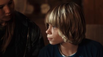 Movie still from “Winter's Bone” (2010), directed by Debra Granik – A young boy with blonde hair looking to his left; Close Up shot, Over the shoulder angle