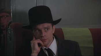 Movie still from “Wise Blood” (1979), directed by John Huston – A man wearing a black hat and a black suit; Close Up shot, Low angle