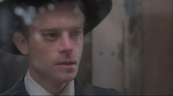 Movie still from “Wise Blood” (1979), directed by John Huston – A person wearing a suit and a hat; Close Up shot, Low angle
