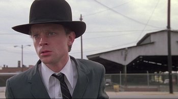 Movie still from “Wise Blood” (1979), directed by John Huston – A man wearing a suit and a black hat; Close Up shot, Low angle