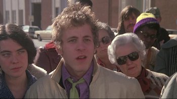 Movie still from “Wise Blood” (1979), directed by John Huston – A young man in a purple shirt and a green tie; Close Up shot, Low angle