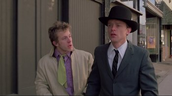 Movie still from “Wise Blood” (1979), directed by John Huston – Two young men in suits and hats talking to each other; Close Up shot, Low angle