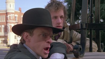 Movie still from “Wise Blood” (1979), directed by John Huston – Two men in hats and jackets are sitting in a car; Close Up shot, Low angle