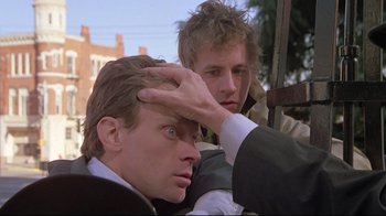 Movie still from “Wise Blood” (1979), directed by John Huston – Two men in business suits are looking at each other; Close Up shot, Low angle