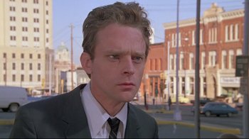 Movie still from “Wise Blood” (1979), directed by John Huston – A person wearing a suit and tie; Close Up shot, Low angle