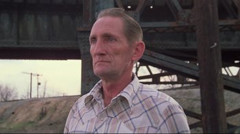 Movie still from “Wise Blood” (1979), directed by John Huston – An older man in a plaid shirt looking at the camera; Close Up shot, Low angle