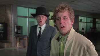 Movie still from “Wise Blood” (1979), directed by John Huston – Two young men in suits and hats in an office building; Close Up shot, Low angle