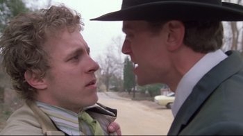 Movie still from “Wise Blood” (1979), directed by John Huston – Two men in suits and ties one of which is wearing a hat; Close Up shot, Over the shoulder angle