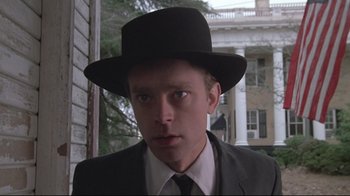 Movie still from “Wise Blood” (1979), directed by John Huston – A man in a suit and a black hat; Close Up shot, Low angle