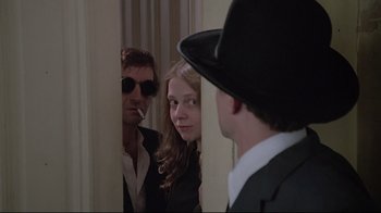 Movie still from “Wise Blood” (1979), directed by John Huston – A group of people standing next to each other in front of a mirror; Medium shot, Over the shoulder angle
