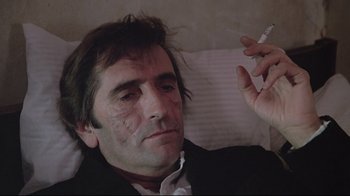 Movie still from “Wise Blood” (1979), directed by John Huston – A person smoking a cigarette on a bed; Close Up shot, High angle