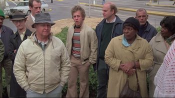 Movie still from “Wise Blood” (1979), directed by John Huston – A group of men standing next to each other; Medium shot, High angle