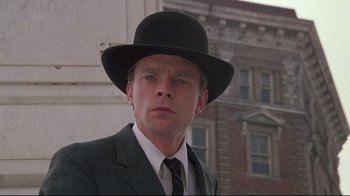 Movie still from “Wise Blood” (1979), directed by John Huston – A man in a suit and a black hat; Close Up shot, Low angle