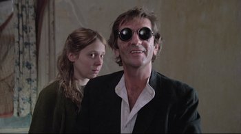 Movie still from “Wise Blood” (1979), directed by John Huston – A man and a woman wearing goggles and a suit; Close Up shot, Low angle