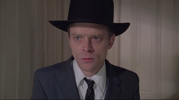 Movie still from “Wise Blood” (1979), directed by John Huston – A man wearing a suit and a hat; Close Up shot, Low angle