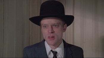 Movie still from “Wise Blood” (1979), directed by John Huston – A man in a suit and a black top hat; Close Up shot, Low angle