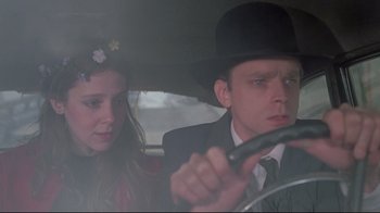 Movie still from “Wise Blood” (1979), directed by John Huston – A man and a woman sitting in a car holding an umbrella; Close Up shot, Low angle