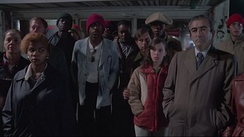 Movie still from “Wise Blood” (1979), directed by John Huston – A group of people standing around each other in the dark; Medium shot, Low angle