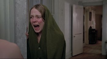 Movie still from “Wise Blood” (1979), directed by John Huston – A woman with a towel over her head is screaming; Medium shot, Low angle