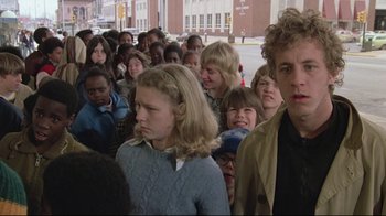 Movie still from “Wise Blood” (1979), directed by John Huston – A group of people standing in the street; Medium shot, Low angle
