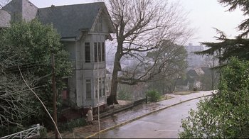 Movie still from “Wise Blood” (1979), directed by John Huston – An old house on the side of the street; Extreme Wide shot, High angle